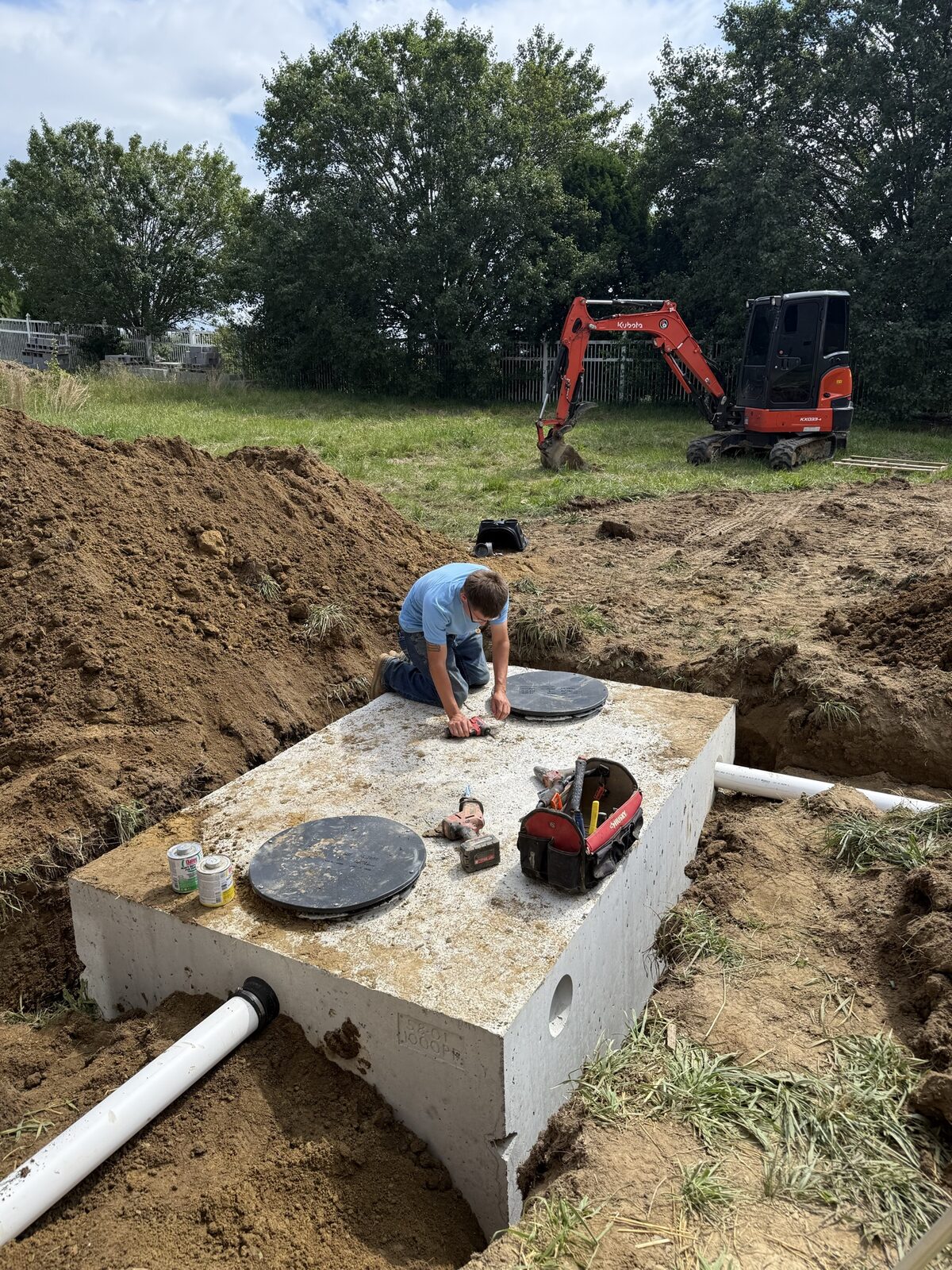 Technician sealing a septic tank lid